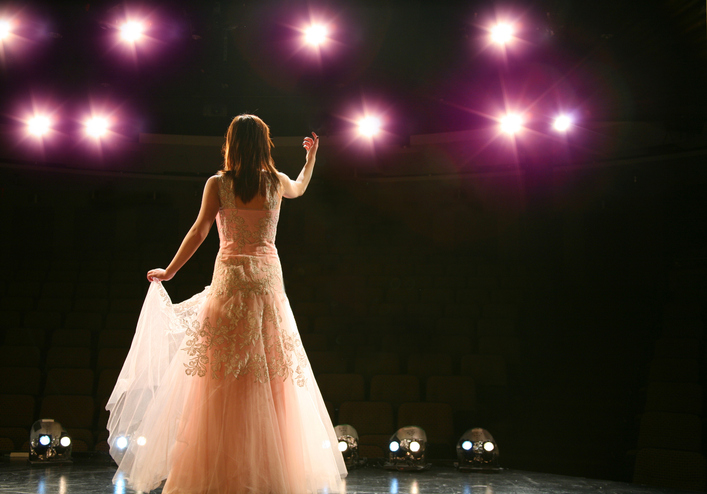 Singer on stage looking into the stage lights