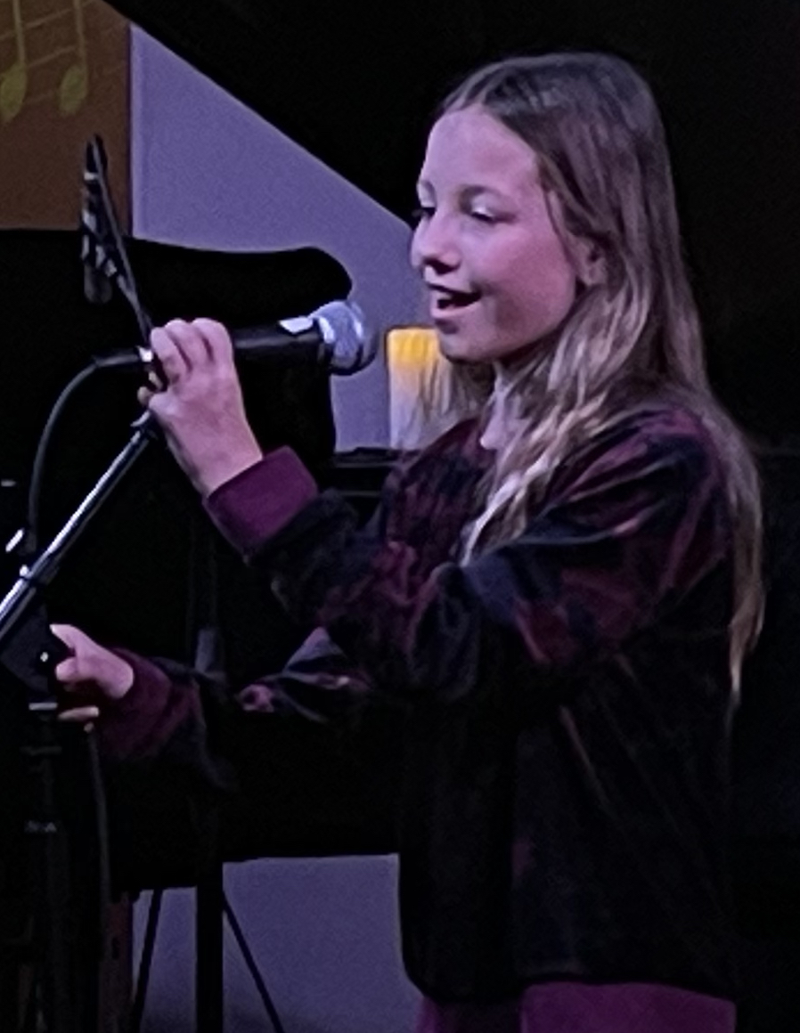 Young girl singing on stage